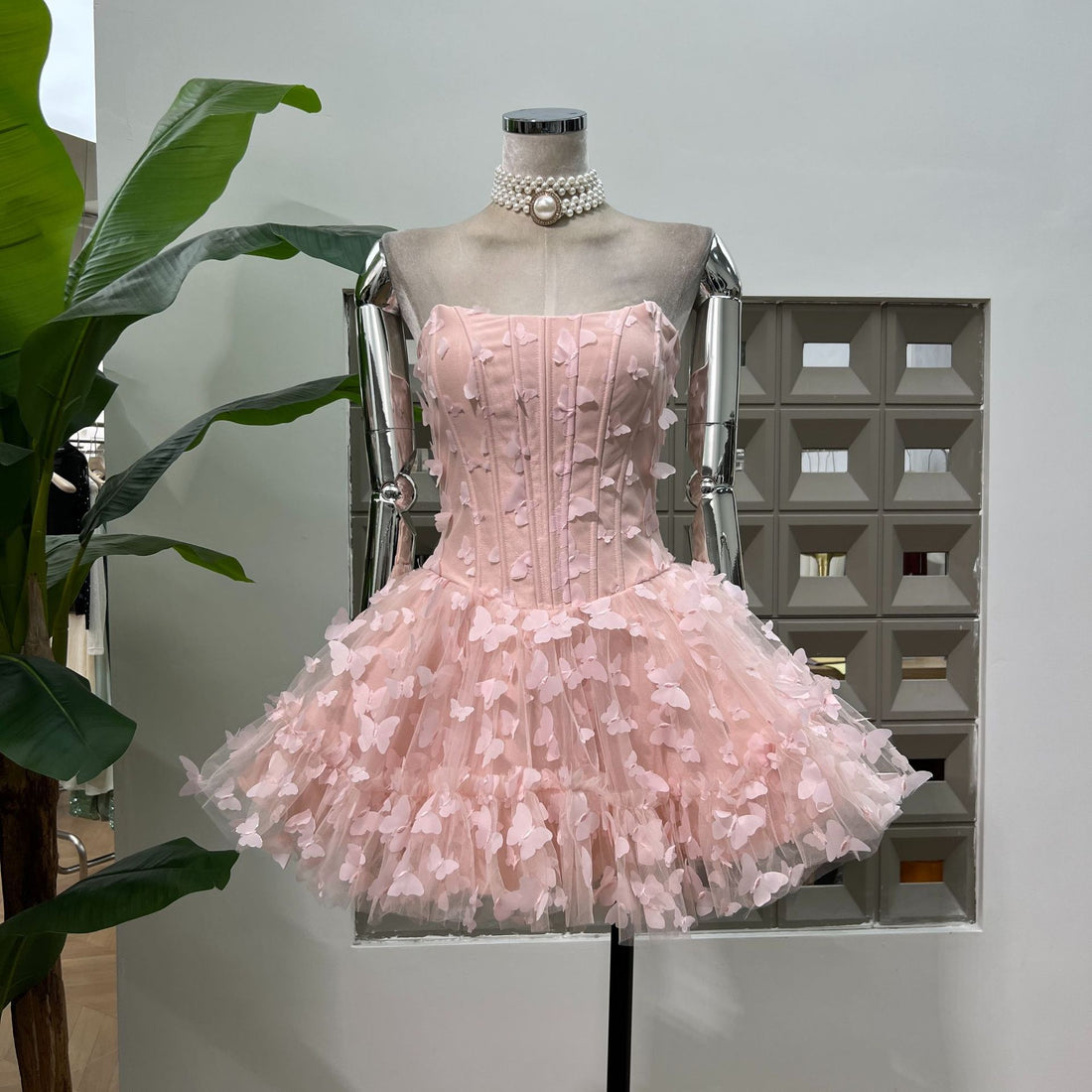 Pink dress with ruffled skirt and matching headband on a white background